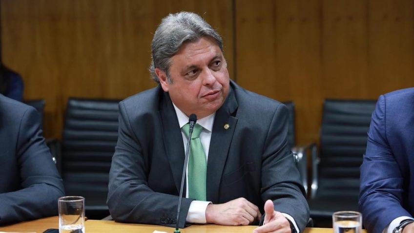 Deputado Júlio Arcoverde em uma mesa falando ao microfone