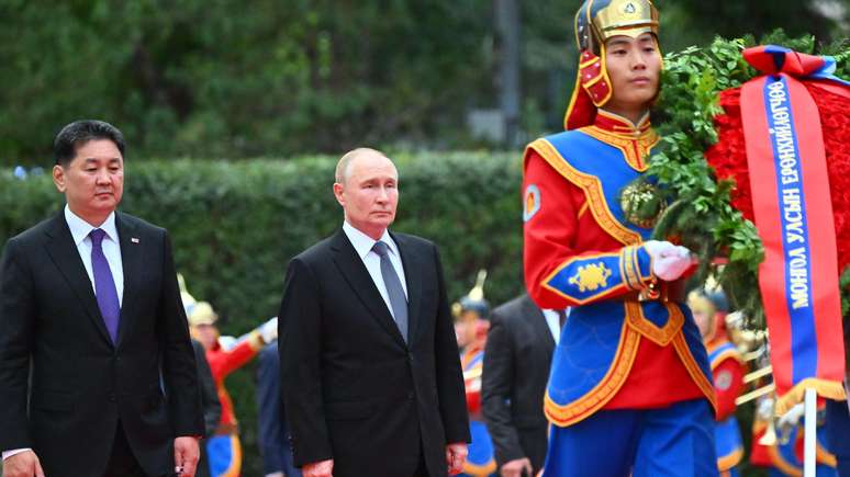 Putin e o presidente da Mongólia caminhando juntos durante uma cerimônia de boas-vindas